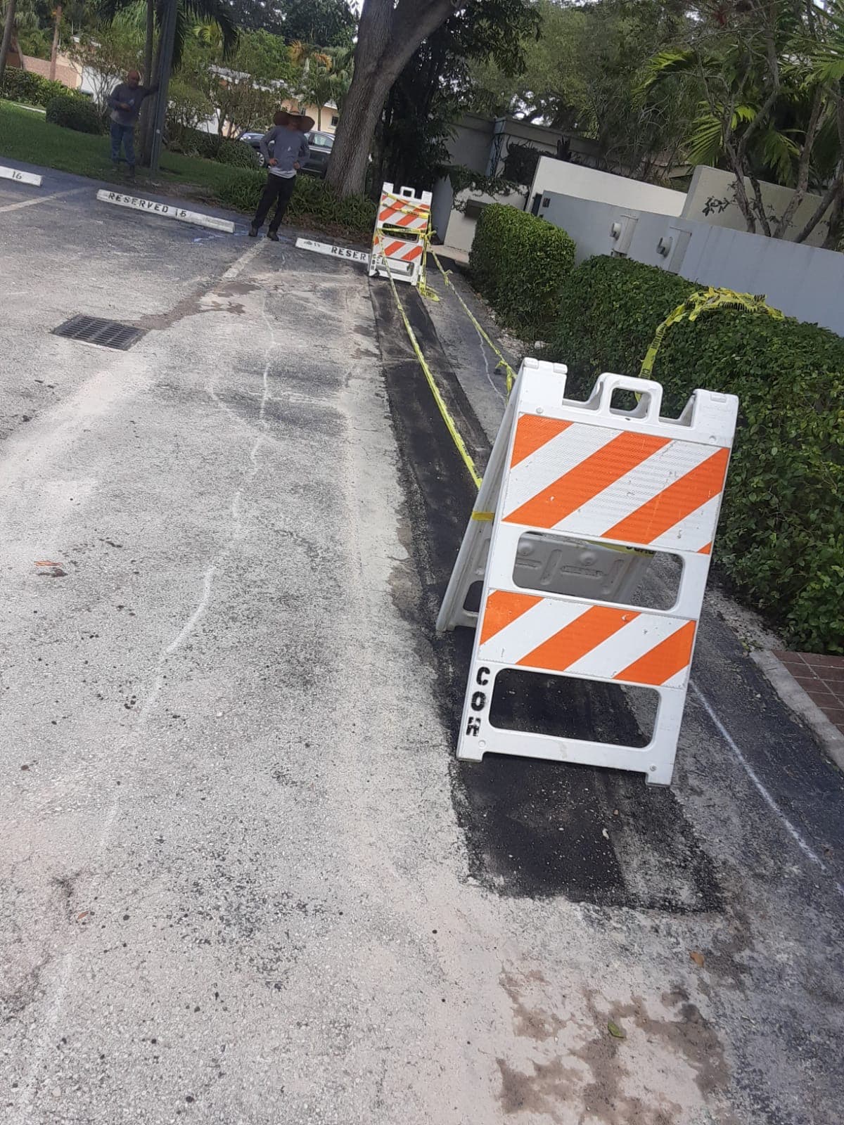 Zanja a lo largo de un estacionamiento, señalizada con barrera