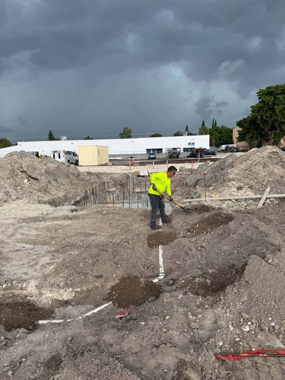 Plomero de RCR marcando el trazado de tubería en un terreno de obra nueva
