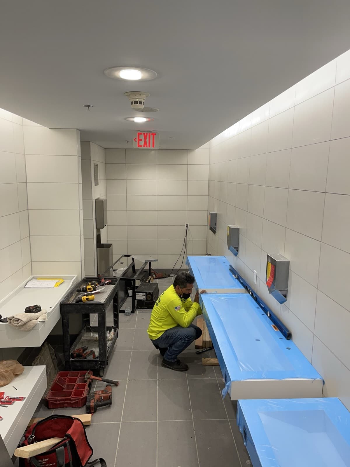 Plomero instalando los lavamanos de un baño comercial