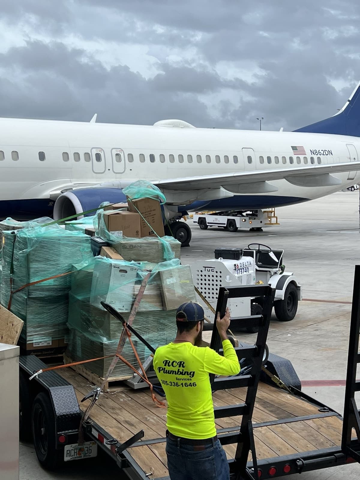 Plomero de RCR descargando material en la plataforma de un aeropuerto