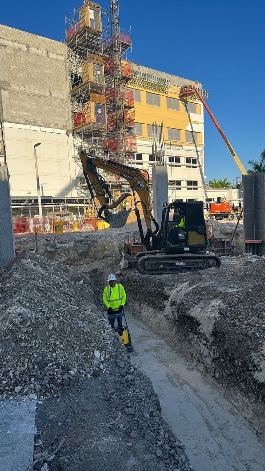 Excavadora y zanja de RCR junto a un edificio en obra del Jackson Memorial Hospital